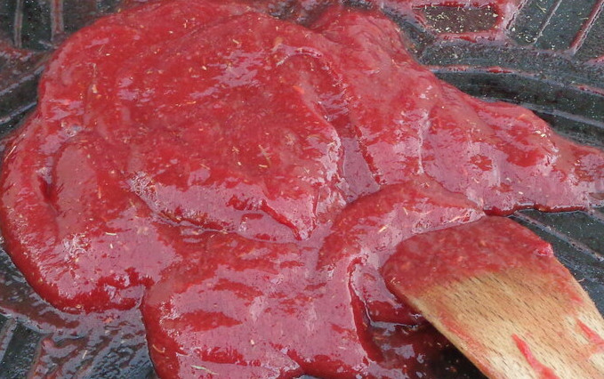 Confiture de tomate Purée de tomate étalée sur un plat avec une spatule en bois